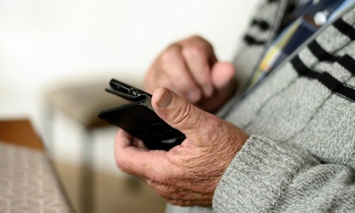 oudere telefoneert aan verminderd tarief