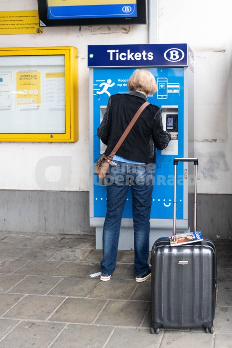 Oudere vrouw koopt treinticket