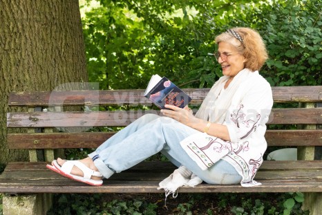 Oudere vrouw leest boek