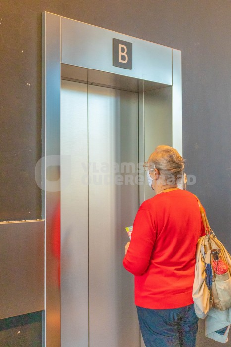 Oudere wacht op de lift
