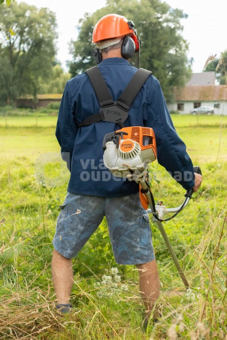 Oudere werkt in de tuin