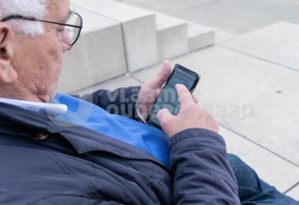 Oudere aan het sms'en