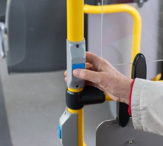 Oudere vrouw drukt op bel in de bus